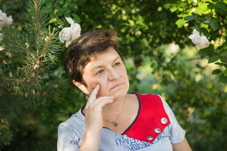 Picture of a middle-aged woman. Concept of emotions. Woman is happy to have rest outdoors after...