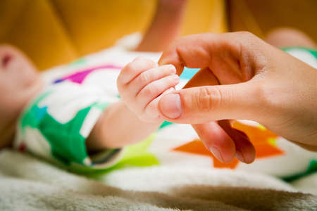 Children Babies. Small hand of a newborn baby in the hands of happy parentsの写真素材