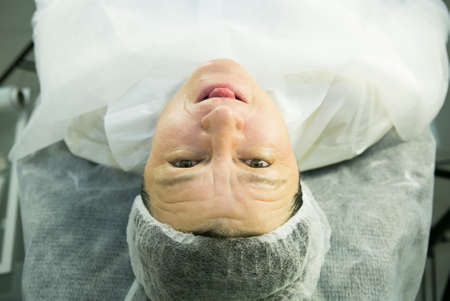 A visit to the beautician. Procedure-carboxytherapy. The doctor removes the rejuvenating mask from the patient's face.の写真素材