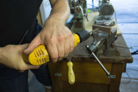 Working with a vise and drill. Master's hands at work. Home workshop.の写真素材
