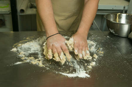 The process of making bread. The chef kneads the dough by hand. The hands of the chef mix all the...