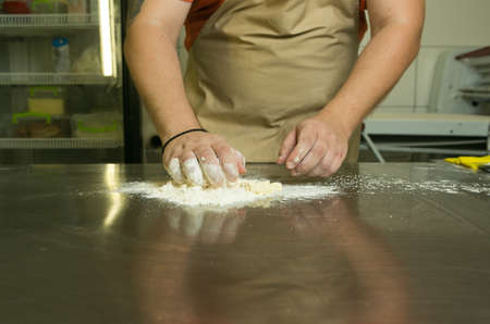 The production process for sweet pastries with fruits. The chef makes the baking dough by hand. The...