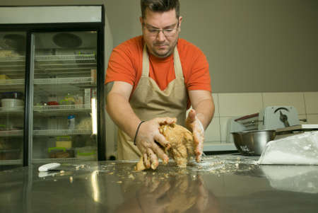 The process of making bread. The chef kneads the dough by hand.