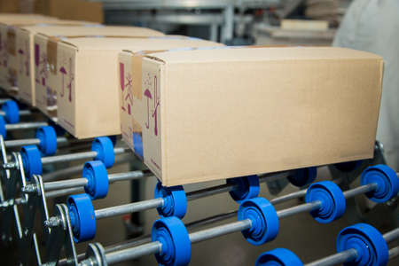 Sweets factory. Sweets production process. Conveyor belt with boxes of chocolates on it.の写真素材