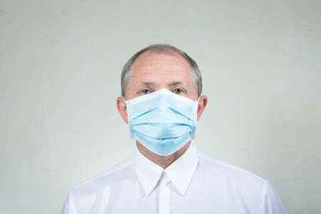 Portrait of a man in a medical mask. A man in white clothes. Isolated on white background.