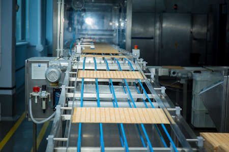 Sweets factory. Sweets production process. Conveyor belt with sweets on it.のeditorial素材