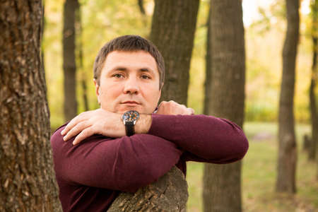 A middle-aged man is resting in the autumn forest. Portrait.の写真素材