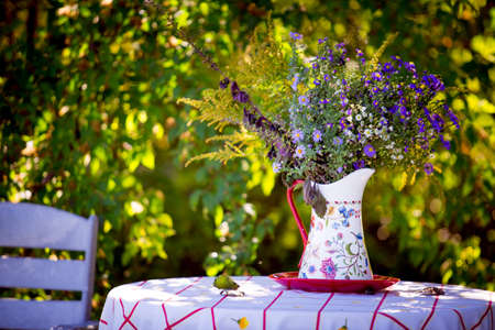 Wildflowers. A bouquet of wild flowers in a vase on a table with a white tablecloth.