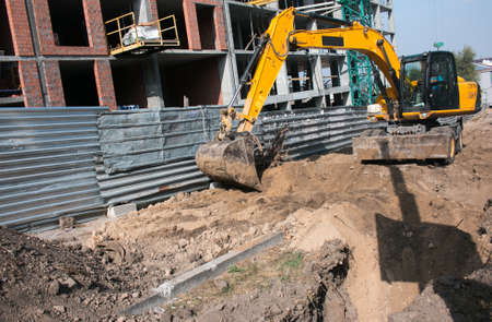 Construction of a new multi-storey building. Bucket excavator work when laying the foundation.