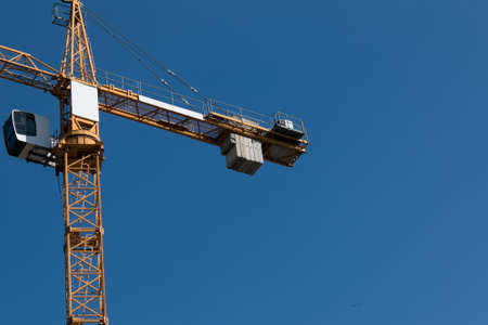 Building. Close-up of a construction crane against the blue sky.の写真素材