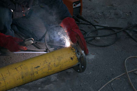 Working with the tool. Hands of a man working with a welding machine. Welding sparks.