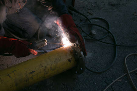 Working with the tool. Hands of a man working with a welding machine. Welding sparks.の写真素材