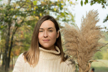 Fall. Portrait of a young beautiful woman with autumn spikelets.の写真素材