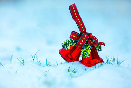 First snow. Christmas card. Christmas bell in the snow. Selective focus.