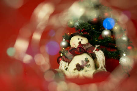 New Year and Christmas card on a red background. Cheerful snowman and Christmas lights.の写真素材