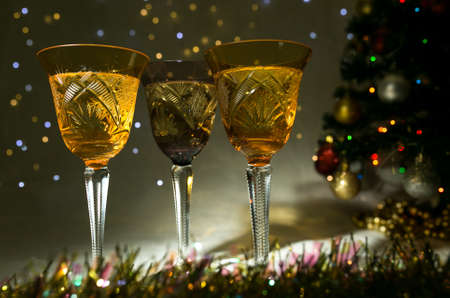 New Year and Christmas card. Glasses of champagne, Christmas tree and lights.の写真素材