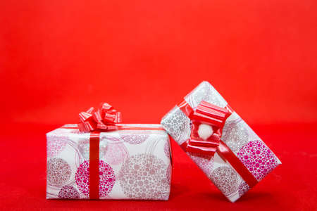 Two gift colorful boxes on a red background. Blank for the designer.の写真素材
