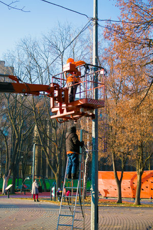 Municipal service decorate street lamp for celebration of Christmas and New Year. Installation and...