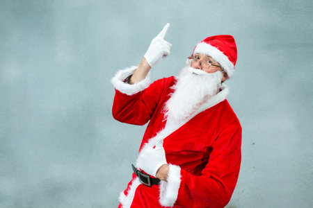 Portrait of Santa Claus on a gray background. Emotion concept. Santa Claus with hand gestures expresses joy at the coming of Christmas. Close-up on a gray background.の写真素材