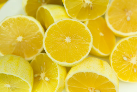 Fresh ripe lemons. A background of a large number of lemons, cut in half, without zest, lying on the table.の写真素材