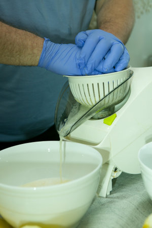 The process of making limoncello lemon liqueur at home. A man squeezes lemon juice on a food...