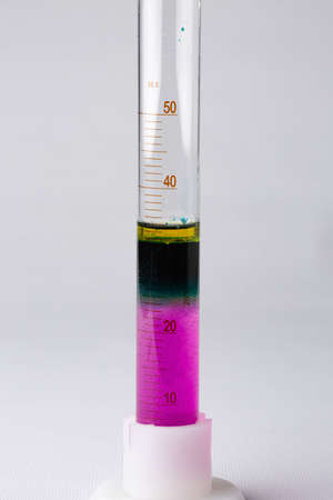 Laboratory test tube on a white background. The glass contains a mixture of chemicals of different colors.の写真素材