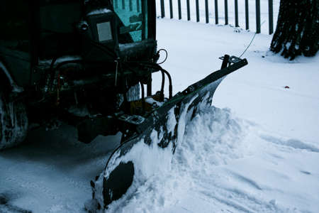 Snowplow removing snow on street after blizzard. Snowplow vehicle clears snowy road during blizzard....