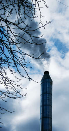 Smoke from chemical factory chimney on cloudy sky background. Ecology theme.の写真素材