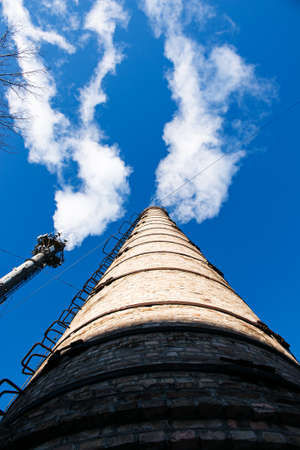 Smoke from chemical factory chimney on cloudy sky background. Ecology theme.