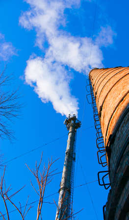 Smoke from chemical factory chimney on cloudy sky background. Ecology theme.