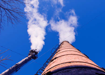 Smoke from chemical factory chimney on cloudy sky background. Ecology theme.