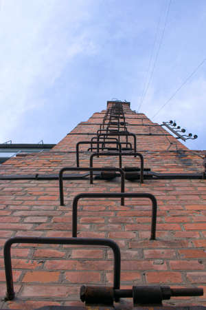 Old and rusty fire escape on the facade of a residential building. The building was built in the last century.の写真素材