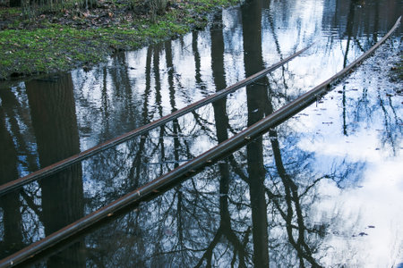 Spring. The snow melts, the water level in rivers and lakes rises. Flooding in the park. The tram rails are flooded with water.の写真素材