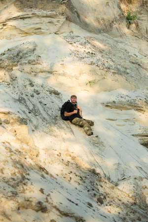 Travel concept. A middle-aged man in tourist clothes walks in the desert. Heat.
