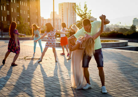 Dnepropetrovsk, Ukraine - 08.08.2017: Joyful townspeople dance on the square in the city at sunset. A couple of young people are happy in the dance.のeditorial素材