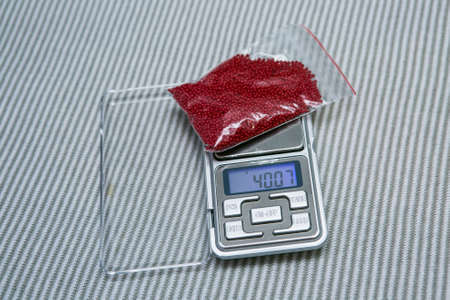 Weaving from beads. Portable scales and packing of beads. Selective focus.