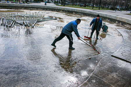 Dnepropetrovsk, Ukraine - 04/08/2021: Cleaning of city fountains in spring before starting work. Workers clean up the dirt that has settled over the season.のeditorial素材