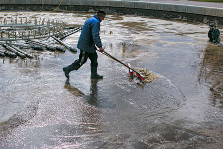 Dnepropetrovsk, Ukraine - 04/08/2021: Cleaning of city fountains in spring before starting work. Workers clean up the dirt that has settled over the season.のeditorial素材