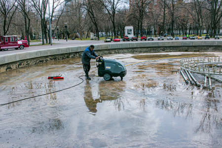 Dnepropetrovsk, Ukraine - 04/08/2021: Cleaning of city fountains in spring before starting work. Workers clean up the dirt that has settled over the season.のeditorial素材