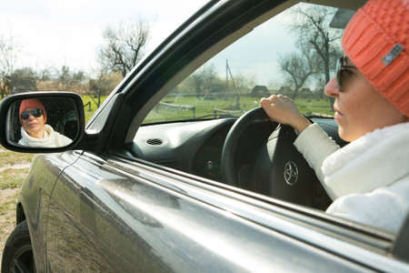 Dnepropetrovsk, Ukraine - 08.04.2021: Portrait of a beautiful woman driving a car. The woman often travels out of town by car. In the face of the coronavirus pandemic, outdoor walks are essential.のeditorial素材
