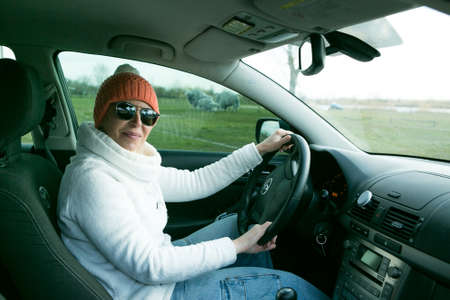 Dnepropetrovsk, Ukraine - 08.04.2021: Portrait of a beautiful woman driving a car. A woman often drives out of town by car. In the situation of the coronavirus pandemic, outdoor walks are necessary.のeditorial素材