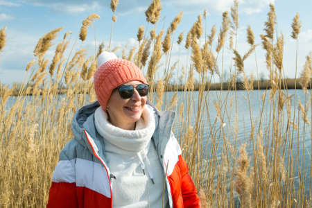 A middle-aged woman walks outdoors in early spring on the river. The woman is dressed in a sporty style.の写真素材