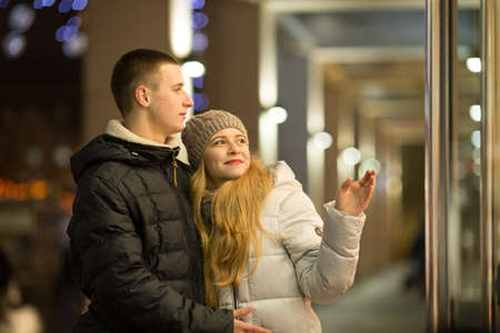 Dnepropetrovsk, Ukraine - 09.12.2016: A couple of young people in front of an expensive store window.のeditorial素材