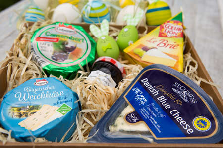 Dnepropetrovsk, Ukraine - 04.23.2021: Delicious fresh Easter breakfast with different types of cheese and beautiful bright Easter eggs on a wooden background.のeditorial素材