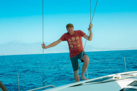 A man on board a sailing yacht at sea. Yachting. Active lifestyle concept.