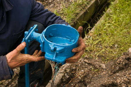 The hands of an electrician are assembling a box of electrical equipment. Maintenance work for...