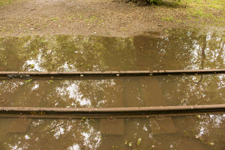 Public park drenched in rain. Water logged park.Wet benches. Park filled with water after rain.Empty park after heavy rain.の写真素材