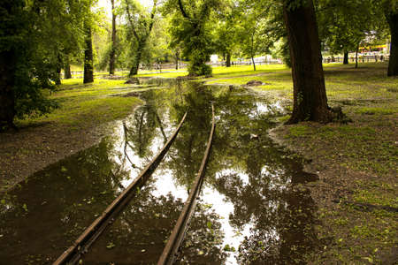 Public park drenched in rain. Water logged park.Wet benches. Park filled with water after rain.Empty park after heavy rain.の写真素材