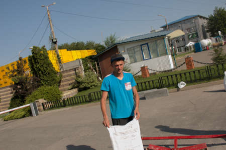 Dnepropetrovsk, Ukraine - 06.26.2021: The process of laying the sidewalk curb. Workers pour the cement out of the bag and mix the grout to anchor the concrete blocks.のeditorial素材