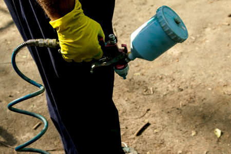 Workers of the municipal city service paint pipes on a playground in the park. Spray painting from a balloon.の写真素材